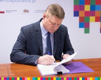 Marek Malinowski, Członek Zarządu Województwa Poldaksiego podpisuje umowę