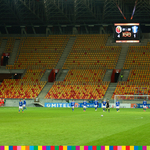 Cieszący się piłkarze Jagiellonii po zdobyciu czwartego gola na tle pustych trybun stadionu