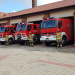 Budynek Komendy Powiatowej Państwowej Straży Pożarnej w Grajewie ze stojącymi wozami strażackimi