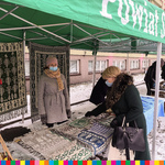 Wiseława Burnos ogląda tkaniny ludowe na stoisku Powiatu Sokólskiego.