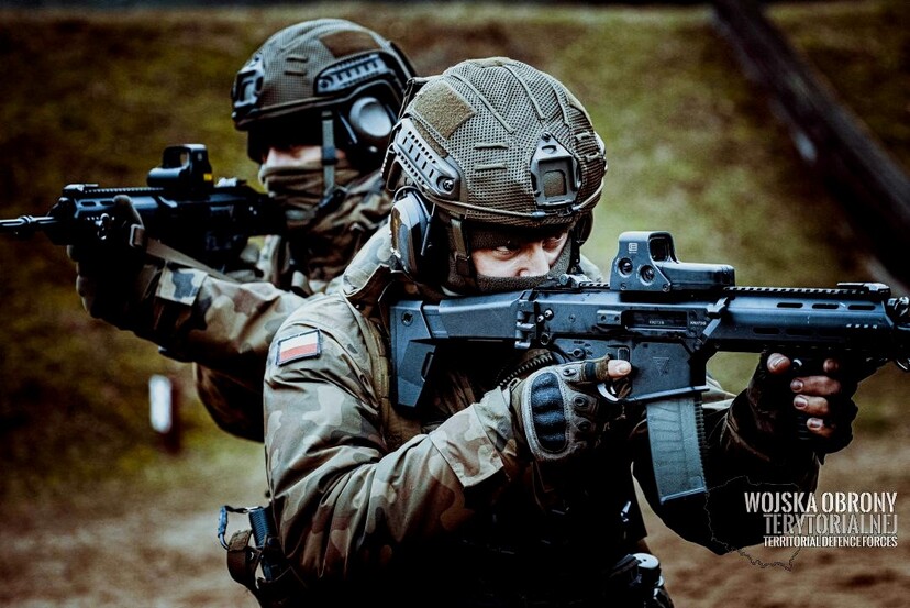 Dwóch żołnierzy trzymających karabiny leży w pozycjach strzeleckich