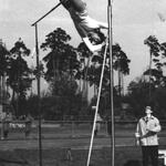 czarno biala fotografia przedstawiająca skaczącego o tyczce zawodnika
