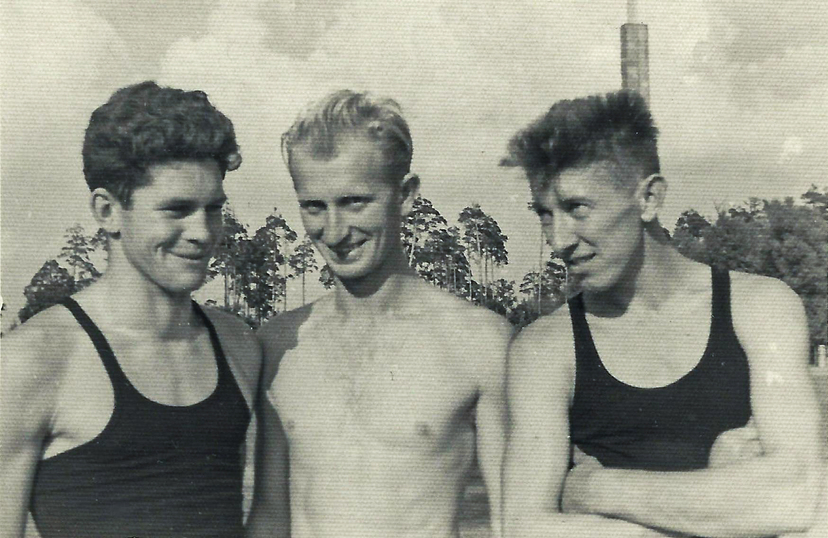 Trzech stojących obok siebie mężczyzn na archiwalnej fotografii