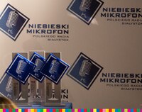 Trzy statuetki plebiscytu  na tle ścianki z napisami Niebieski Mikrofon Polskiego Radia Białystok