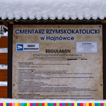 Tablica informacyjna z napisem Cmentarz Rzymskokatolicki w Hajnówce