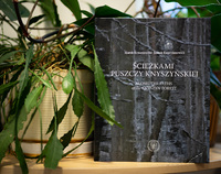 Okładka albumu o Puszczy Knyszyńskiej stojąca przy doniczce