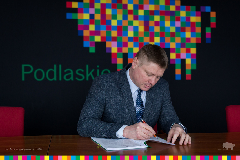 Marek Malinowski w trakcie podpisywania umowy.