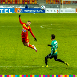 Białostocki zawodnik główkuje piłkę przed nadbiegającym zawodnikiem Legii
