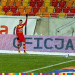 Piłkarz Jagiellonii podnosi rękę przed oddaniem strzału z rzutu wolnego