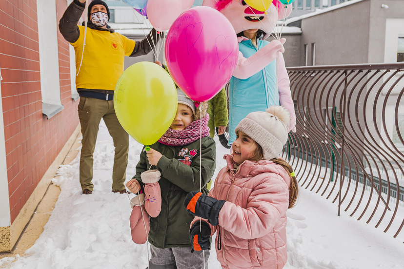 Dwie dziewczynki trzymają w rączkach balony.