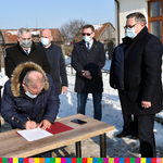 Wicemarszałek Marek Olbryś podpisuje petycję. W tle stoi grupa mężczyzn