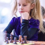 Dziewczynka nad szachownicą zastanawia sie na kolejnym ruchem