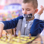 Młody chłopak przestawia pionek na szachownicy