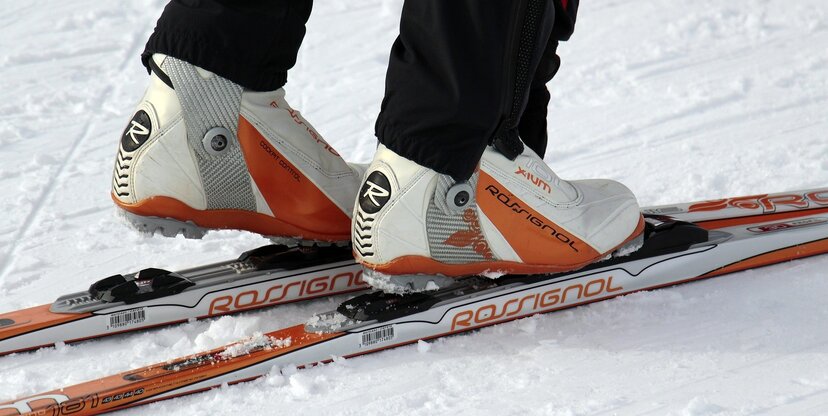 Widoczne nogi stojące na nartach biegowych. Wokół widoczny śnieg