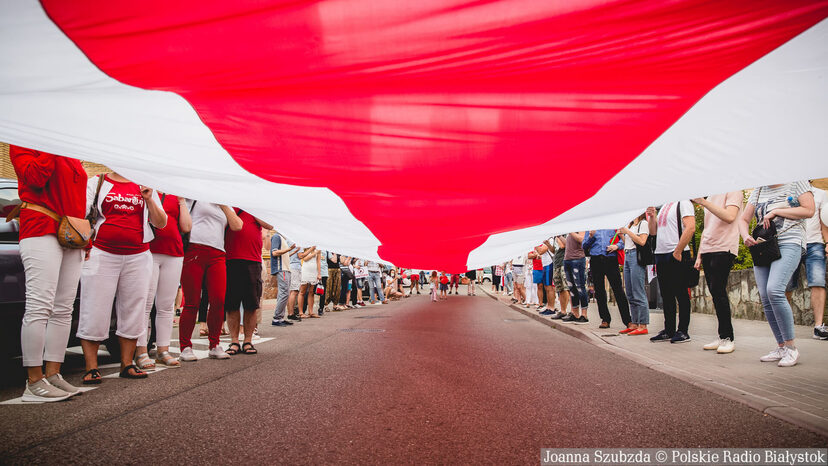 Białoruska flaga trzymana przez wiele osób