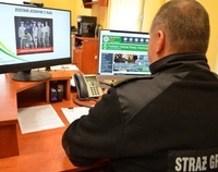 Funkcjonariusz straży przed ekranem monitora podczas szkolenia online.