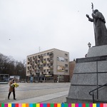 Po prawej pomnik papieża. Po lewej dyrektor Jabłoński idzie z kwiatami w stronę pomnika.