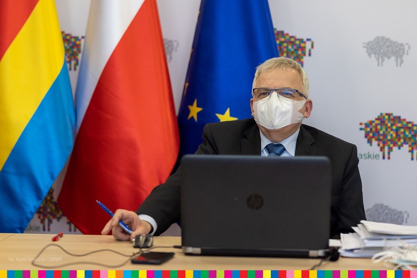 Bogusław Dębki, przewodniczący Sejmiku Województwa Podlaskiego, siedzi w masce przed komputerem podczas sesji online