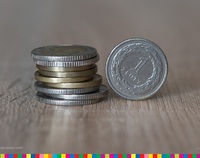Monety ułożone jedna na drugiej, obok złotówka