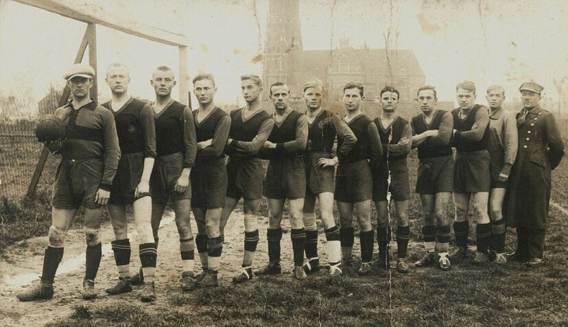 Dwunastu piłkarzy i mężczyzna w mundurze wojskowym.