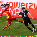 Piłkarz Jagiellonii i Cracovii walczą o piłkę na boisku.