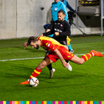 Piłkarz Jagiellonii i Cracovii walczą o piłkę na boisku.