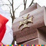 Na kamiennym pomniku przypominającym krzyż widnieje krzyż Orderu Wojennego Virtuti Militari