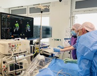Dwoje lekarzy na sali operacyjnej patrzy na ekran komputera