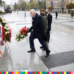 Przewodniczący Sejmiku kładzie wieniec z kwiatami. Za nim stoi żołnierze oraz mężczyźni w płaszczach