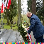 Tomasz Szeweluk, sekretarz województwa stawia wieniec przed pomnikiem.