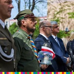 Mężczyźni w mundurach i garniturach stoją w rzędzie obok siebie
