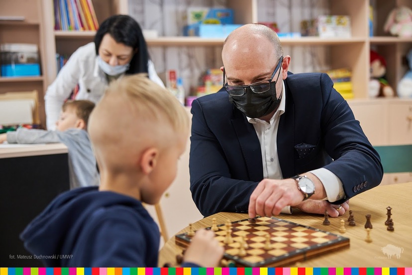 Marszałek Artur Kosicki gra w szachy z dzieckiem