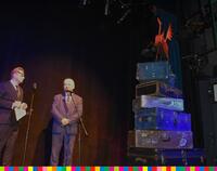 Dwóch mężczyzn stojących na scenie podczas otwarcia 34. Międzynarodowego Festiwalu Walizka. Obok nich stoją walizki