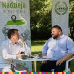 wicemarszałek Stanisław Derehajło rozmawia z drugim mężczyzna przy stoliku