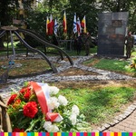 Pomnik, flagi i wieńce widoczne przy pomniku