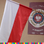 Flaga Polski, w tle tabliczka z orłem i nazwą jednostki OSP Hornowo