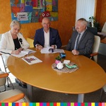 Trzy osoby siedzące przy biurku