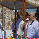 Mężczyźni noszą baldachim, pod którym znajduje się kapłan niosący monstrancję z Najświętszym Sakramentem