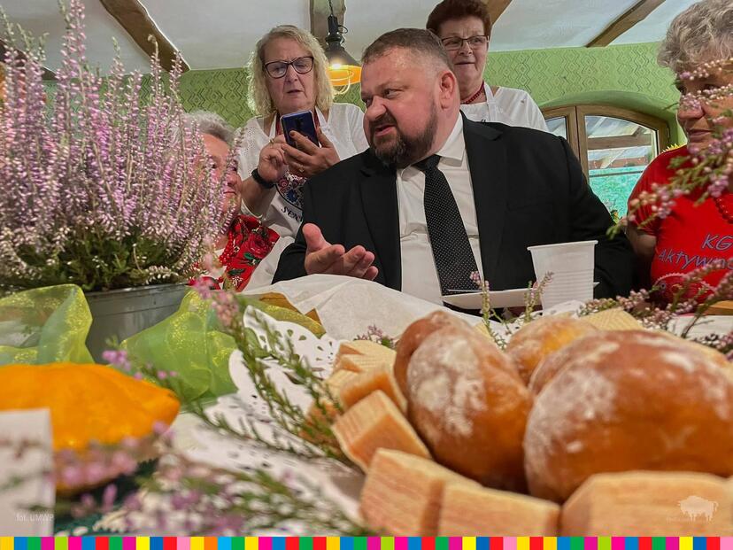 Wicemarszałek Stanisław Derehajło siedzi przy stole na którym stoją produkty regionalne
