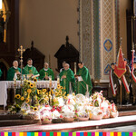 Księża na ołtarzu podczas mszy, pod ołtarzem wieńce dożynkowe