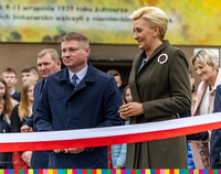 Marszałek Marek Malinowski wraz z Pierwszą Damą stoją przy biało-czerwonej wstędze