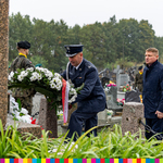 mundurowy składa kwiaty za nim stoi Marszałek Marek Malinowski podczas uroczystości na cmentarzu
