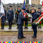 Marszałek Marek Malinowski przekazuje wieniec kwiatów mundurowemu