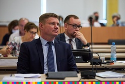 Marek Malinowski, członek zarządu, siedzący w sali sejmikowej, za nim inni radni