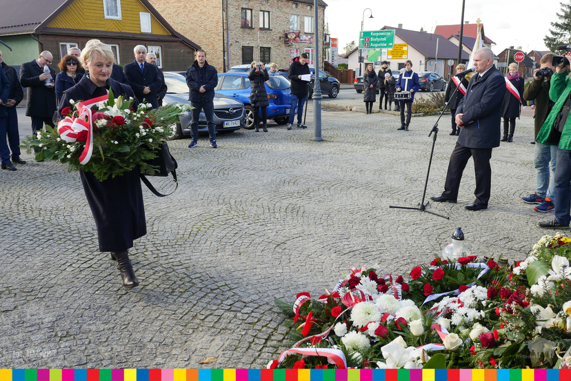 Wiesława Burnos, członek zarządu składa kwiaty. W tle osoby stojące na placu
