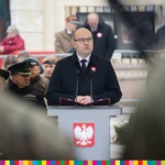 Marszałek Artur Kosicki przemawia z mównicy, na której jest godlo Polski