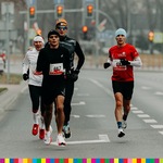 Biegnie czterech mężczyzn ubranych na czarno, biało i biało-czerwono