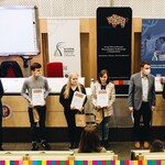 Laureaci Olimpady Wiedzy o Pszczelarstwie stoją obok siebie w rzędzie i trzymają dyplomy. Obok nich organizatorzy olimpiady