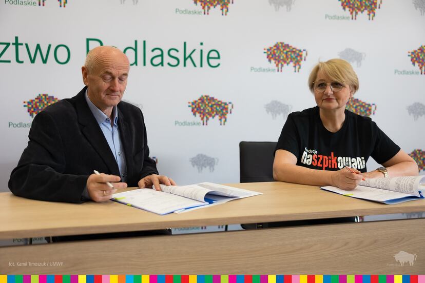 Wiesława Burnos i Jan Joka przy stole w trakcie podpisywania umów.