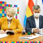 Wiesława Burnos  i Paweł Mikłasz podpisują dokumenty. 
